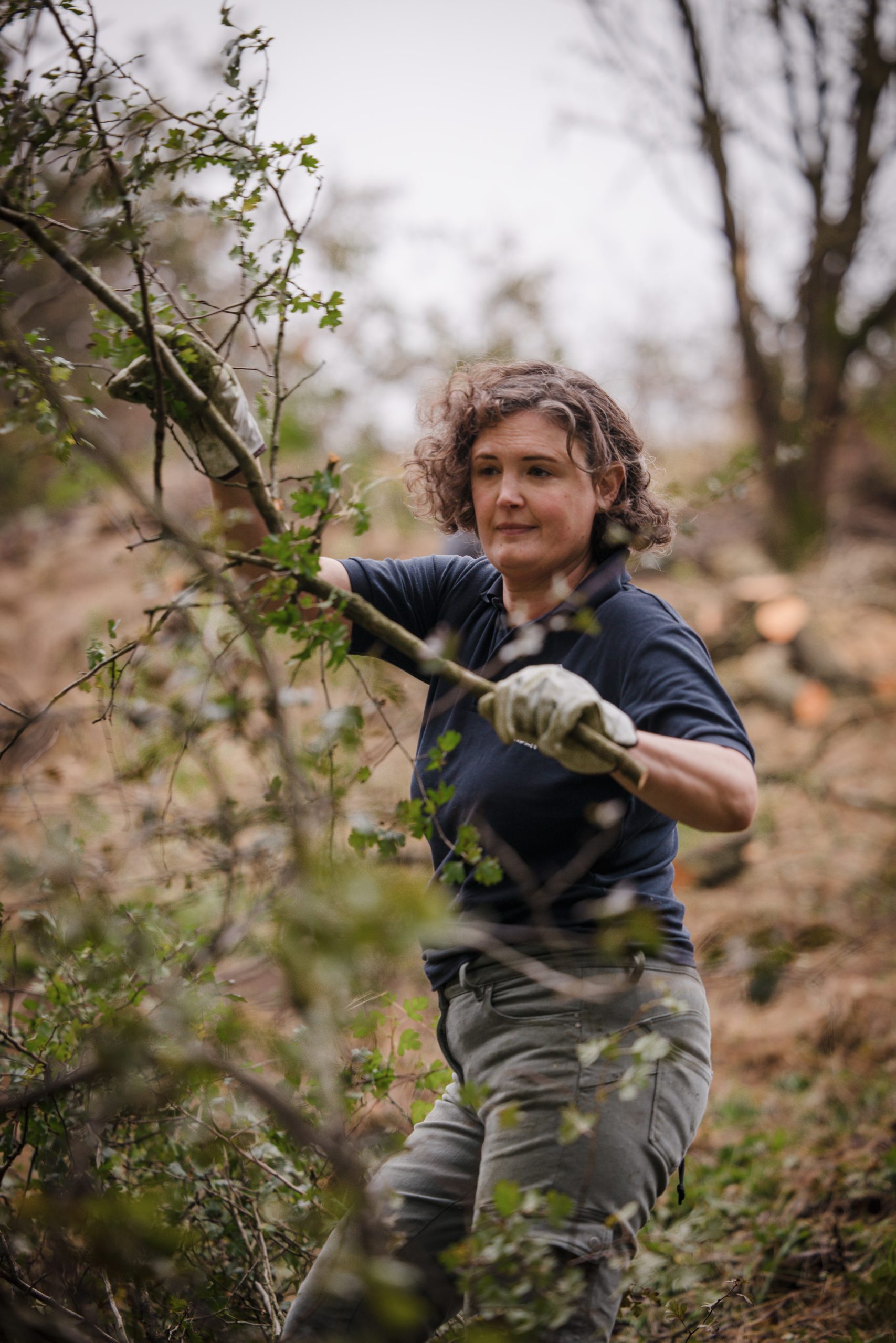 Image of Cerian Brogan working outside to clear scrubland.